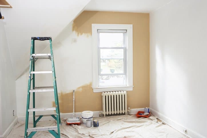 Chambre en cours de mise en peinture, escabeau et bâche de protection